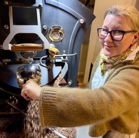 Eigentümerin am Kaffeeröster bei der Ausgabe von frischgeröstetem Kaffee
