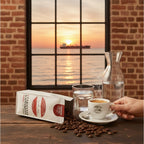 weiße Kaffeetüte des Cuxhavener Kaffeeroesters mit der Aufschrift Espresso Milano auf Tisch mit frisch gebrühtem Espresso und Fenster mit Nordseeblick