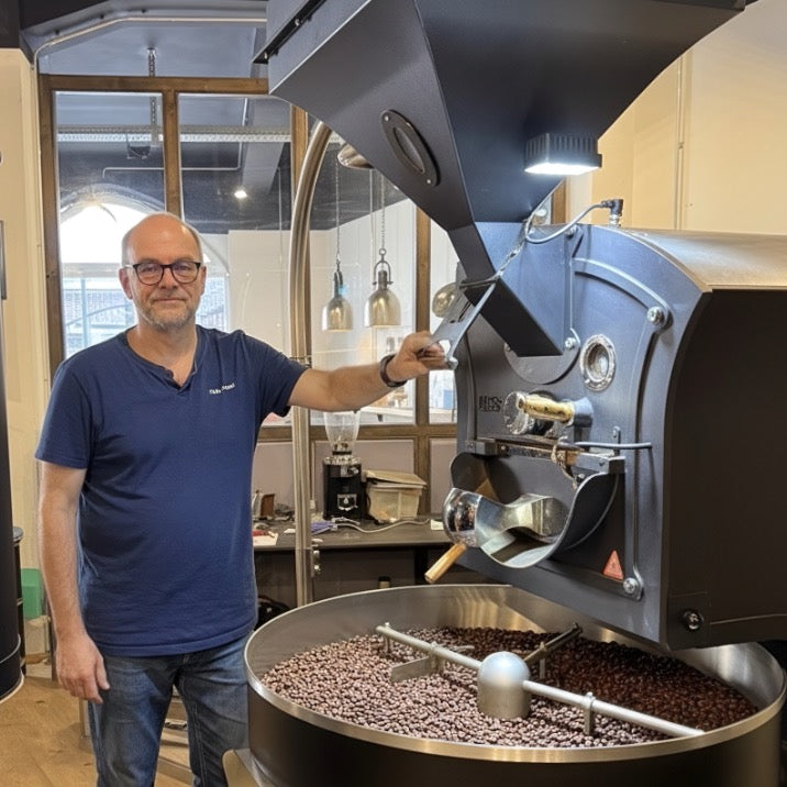 Eigentümer beim Rösten von Kaffeebohnen an Kaffeeröstmaschine