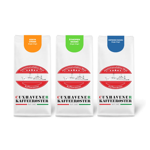Weiße Kaffeetüten des Cuxhavener Kaffeeroesters eingebunden in Werbung für Afrika De Luce 3x500g freigestellt vor weissem Hintergrund