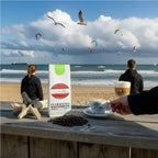 Weiße Kaffeetüte des Cuxhavener Kaffeeroesters mit der Aufschrift Brasil Yellow Bourbon  auf Theke mit Nordseeblick und Kite-Szene