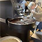 Eigentümerin beim Probenzug an Kaffeeröstmaschine