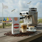Weiße Kaffeetüte des Cuxhavener Kaffeeroesters mit der Aufschrift El Salvador mit Siebträgermaschine und Nordseeblick