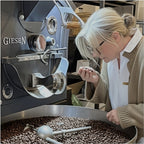 Inhaberin bei der sensorischen Prüfung von frisch gerösteten Kaffeebohnen am Kaffeeröster