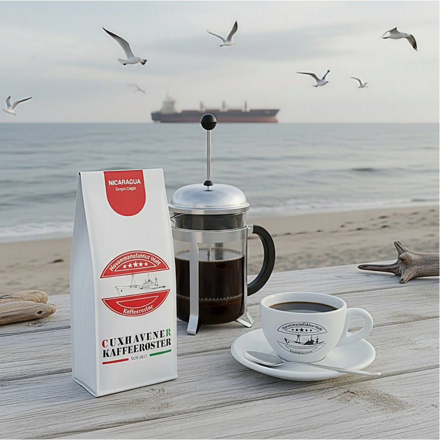 Weiße Kaffeetüte des Cuxhavener Kaffeeroesters mit der Aufschrift Nicaragua   mit French Press auf Bar vor Nordseestrand