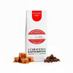 Weiße Kaffeetüte des Cuxhavener Kaffeeroesters mit der Aufschrift SOS Cuxhaven und Aromasymbolen vor weißem Hintergrund